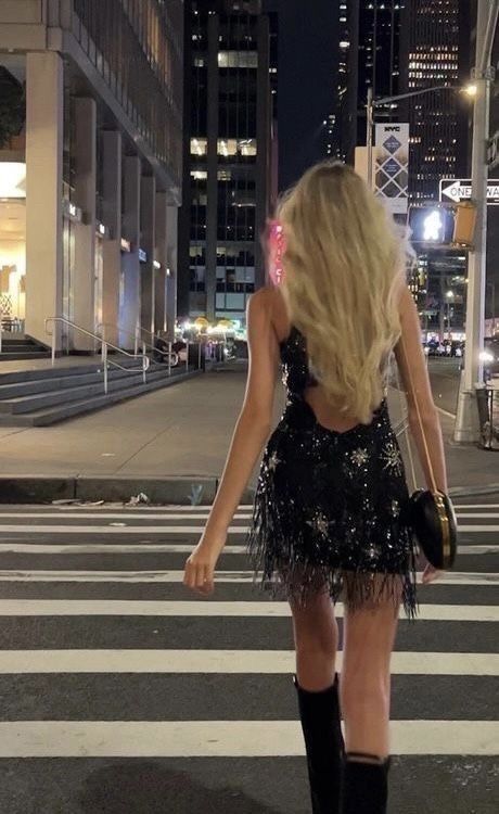 Back view of the black sequin halter dress showing open back and fringe detail.