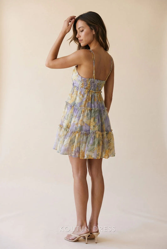 Back view of watercolor floral mini dress showing smocked detail and tiered ruffles.