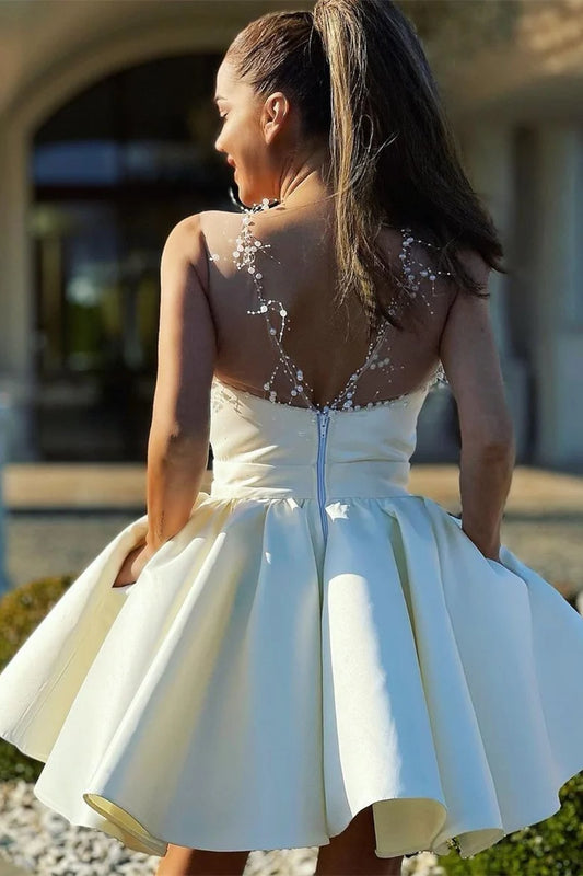 Back view of ivory A-line homecoming dress showing illusion back with zipper detail.