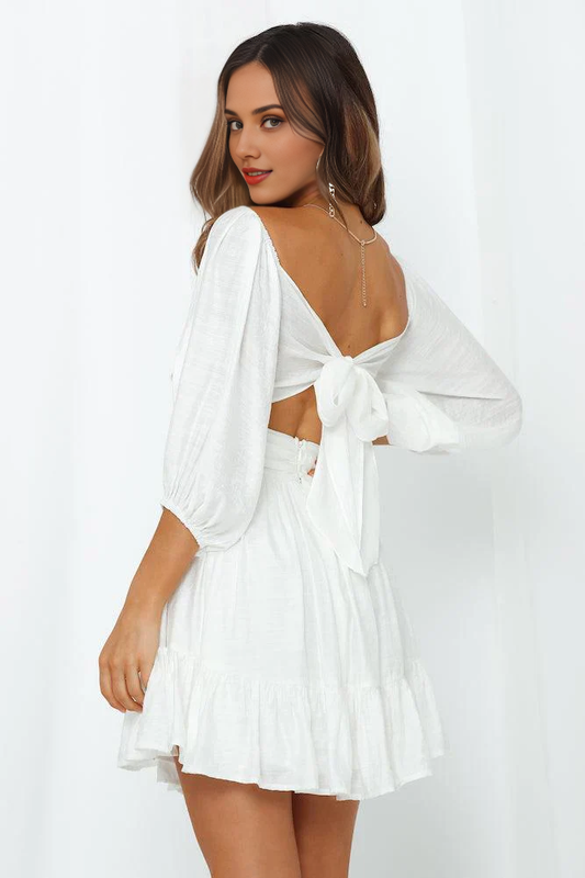 Elegant white tiered mini dress with off-shoulder design.