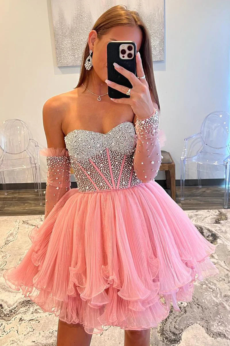 Close-up of the pink A-line sweetheart long sleeve beaded homecoming gown, showing intricate beading details.