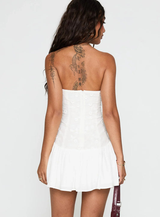 Back view of the white strapless dress, showing ruffled hem detail.