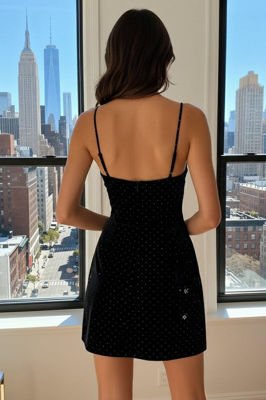 Close-up of the black velvet mini dress, highlighting the rhinestone embellishments and silver bow.