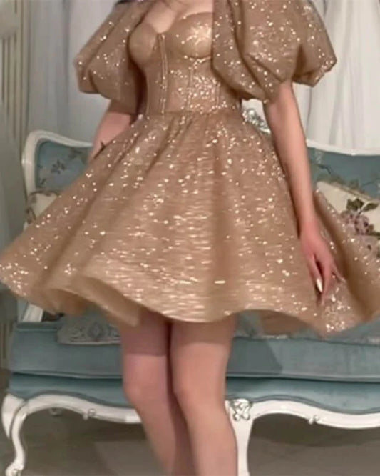 Close-up of the sparkling gold fabric and short sleeves on the A-line homecoming dress.