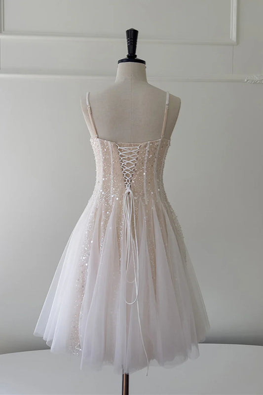 Model posing in a champagne sequin A-line homecoming dress.