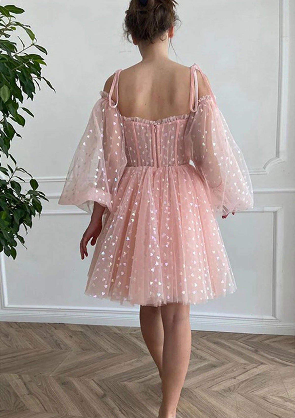 Back view of the blush pink off-shoulder puff sleeve A-line homecoming dress with corset detail.