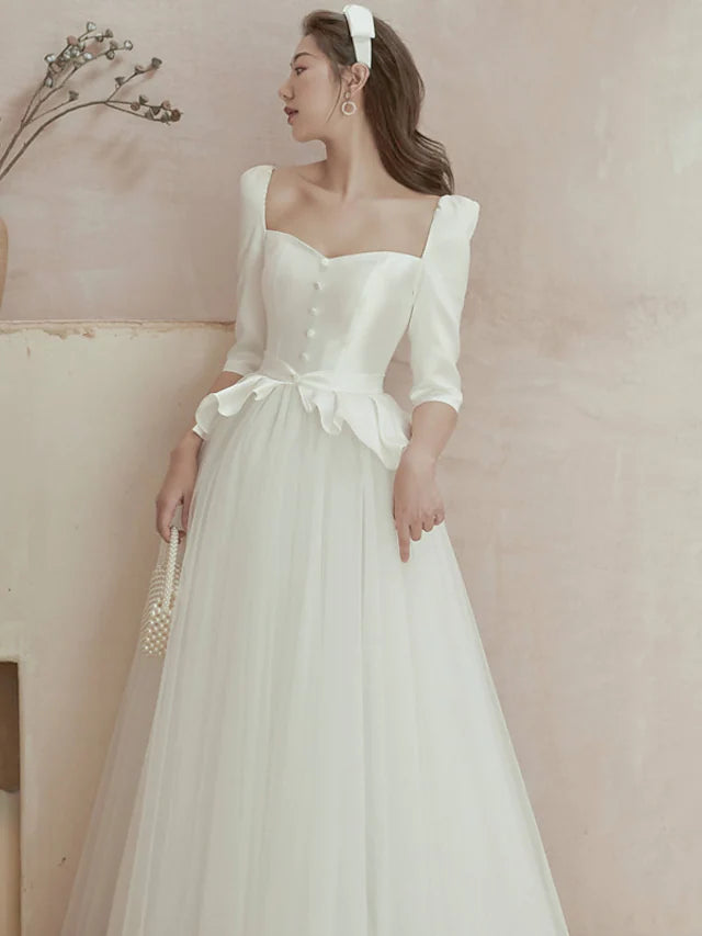 Back view of a floor-length satin wedding gown with delicate ruffles and pleats.