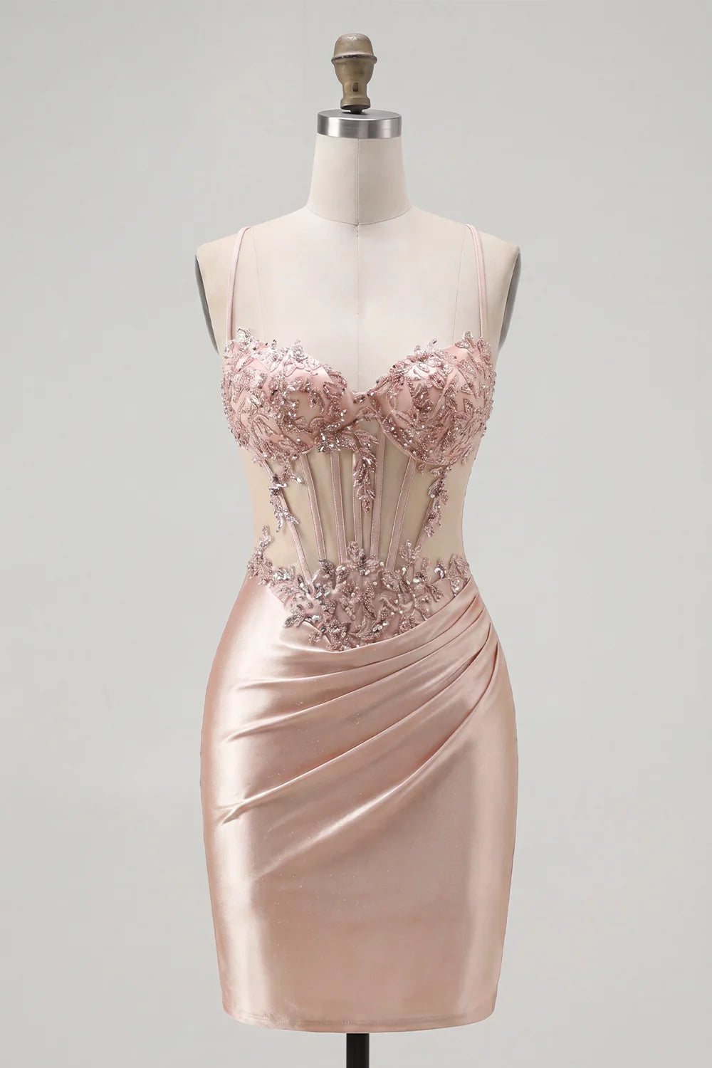 Full length view of a model elegantly posing in the blush pink spaghetti strap dress.