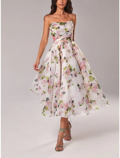 Model wearing an A-line tea length dress with spaghetti straps and floral print.