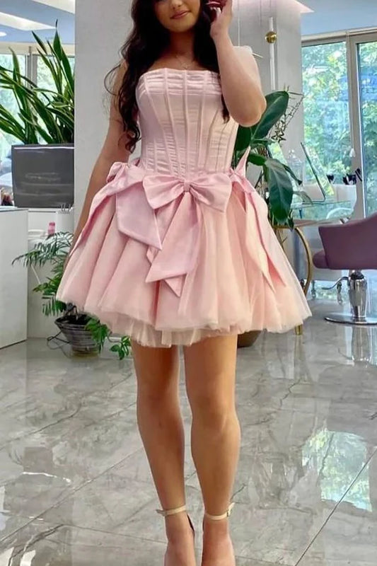 Pink A-line strapless homecoming dress with corset bodice and large back bow.