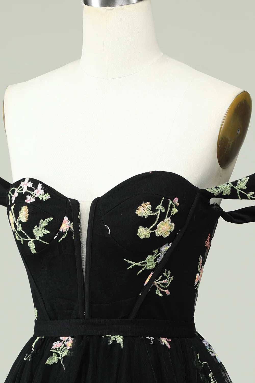 Model wearing a black A-line sweetheart off-shoulder floral print homecoming dress.