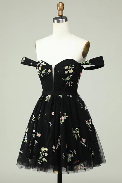 Side view of a model in a black floral print A-line homecoming dress.