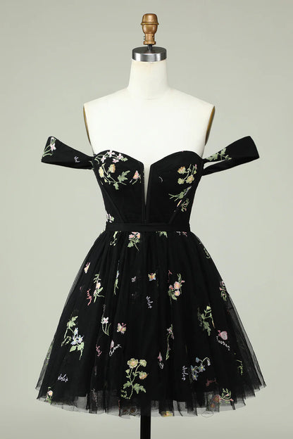 Detail of the black floral pattern and off-shoulder design.
