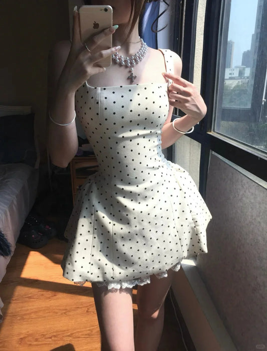 Model wearing a white polka dot corset mini homecoming dress with a square neck and lace trim.