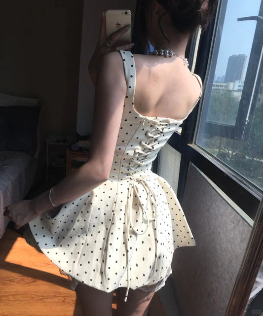 Back view of the white polka dot corset mini dress, showing the lace-up detail.