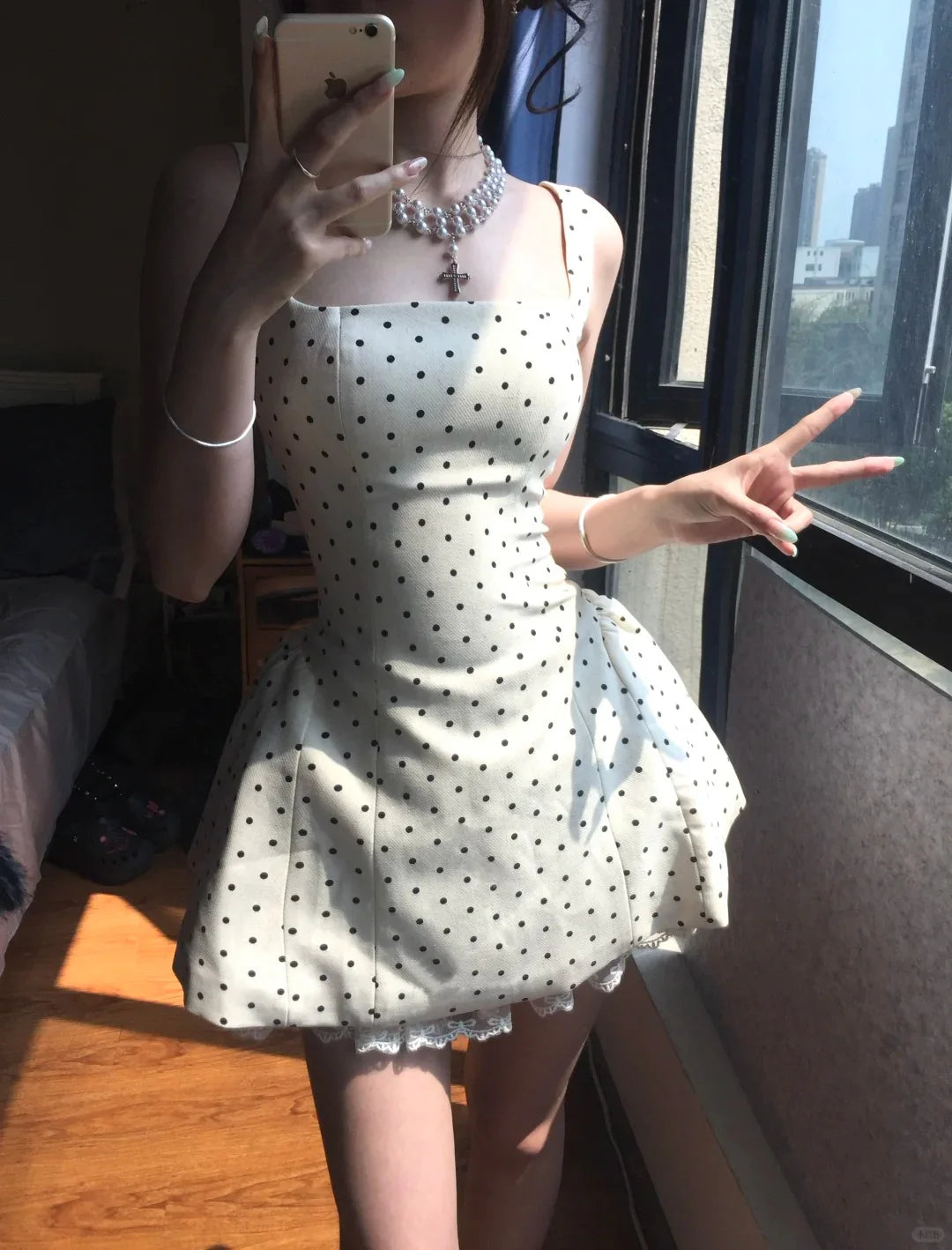 Close-up of the square neckline and white fabric with black polka dots on the dress.