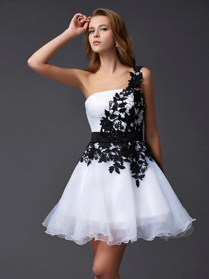 Model wearing a periwinkle A-Line Princess one-shoulder short homecoming dress with lace and organza details.