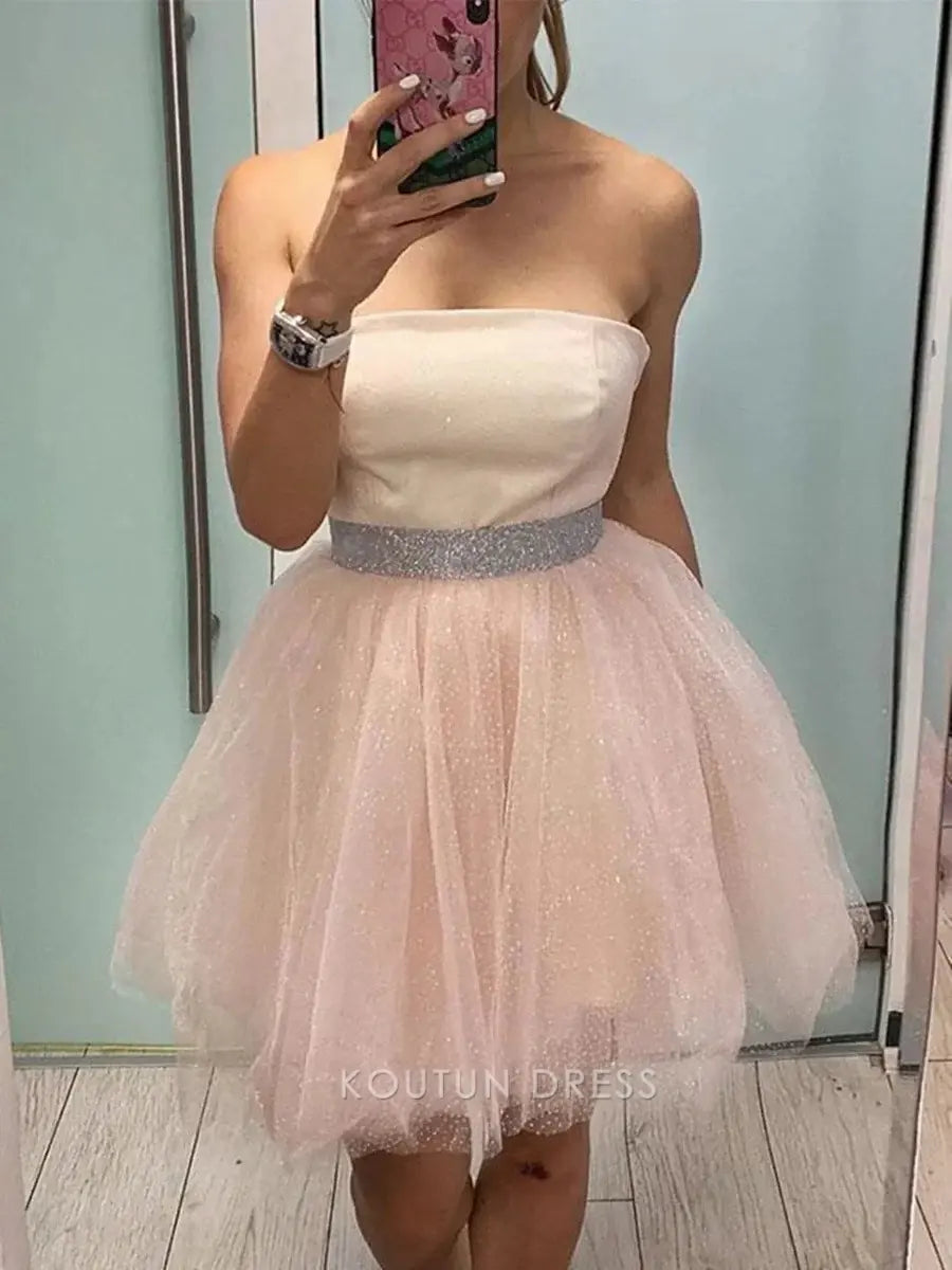 Close-up of the blush pink satin bodice and sparkling rhinestone waistband on the mini dress.