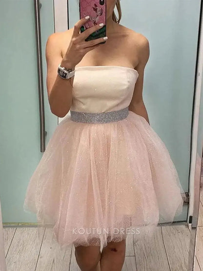 Close-up of the blush pink satin bodice and sparkling rhinestone waistband on the mini dress.