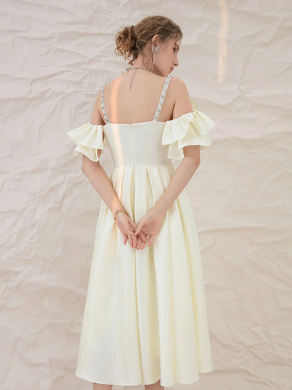 Model posing in a light yellow satin A-line homecoming dress.