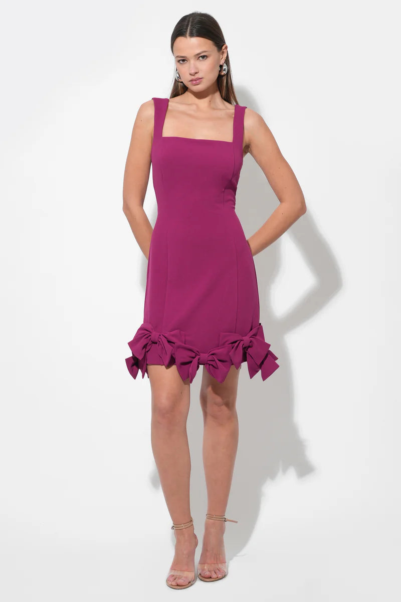 Model wearing a chic A-line mini homecoming dress with a bow skirt and spaghetti straps.
