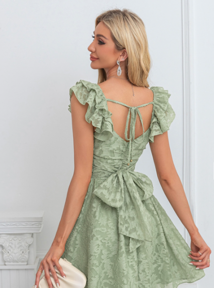 Close-up of jacquard fabric and bow on A-line mini dress.