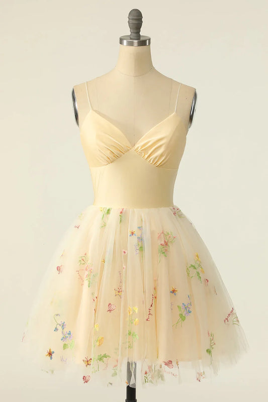 Model wearing a champagne tulle A-line V-neck homecoming dress with intricate embroidery.