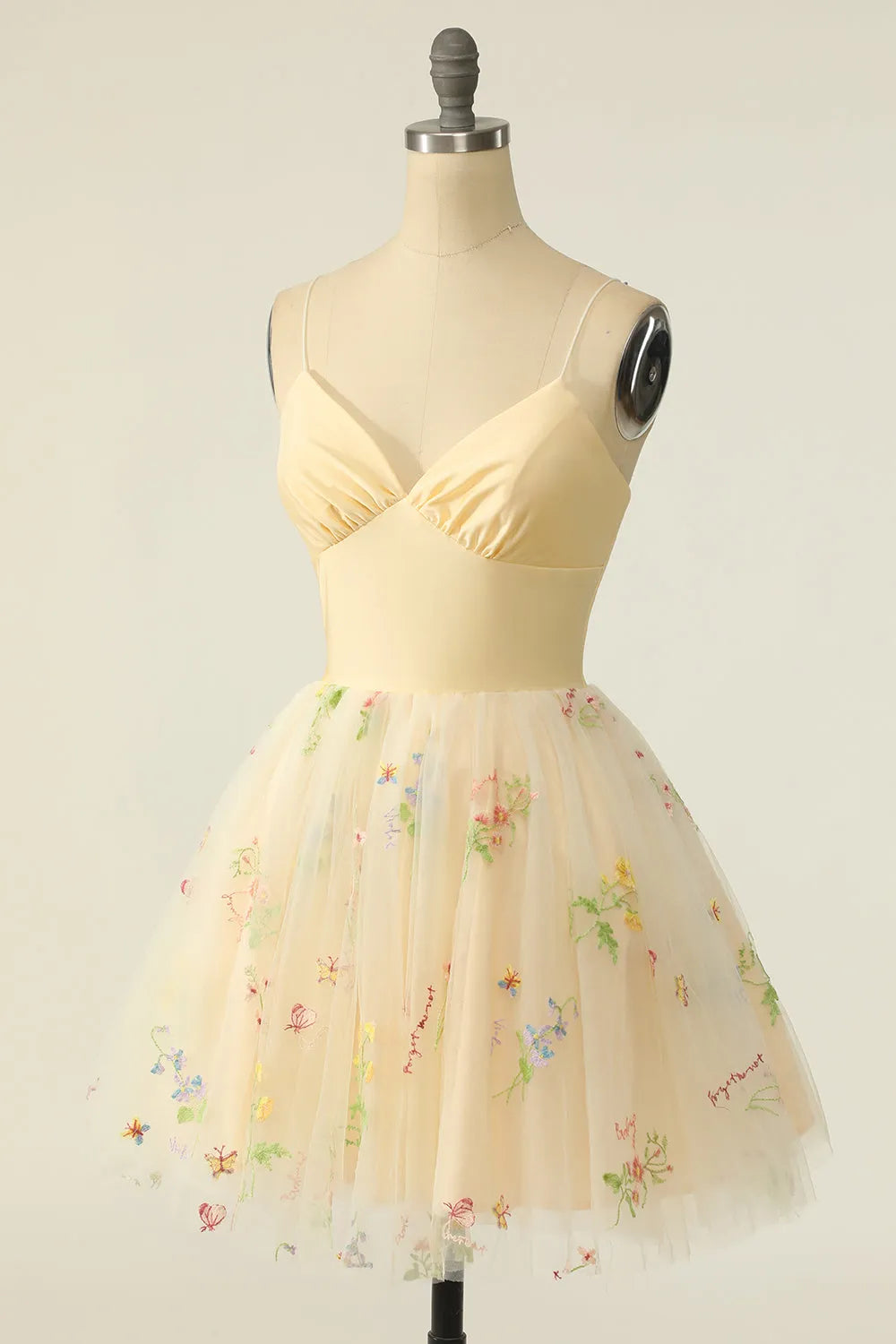 Close-up of the V-neckline and delicate embroidery on the champagne tulle dress.