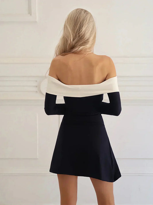 Side view of the black and white off-shoulder long sleeve mini dress.