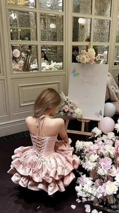 Back view of a pink strapless ruffled tiered mini dress.