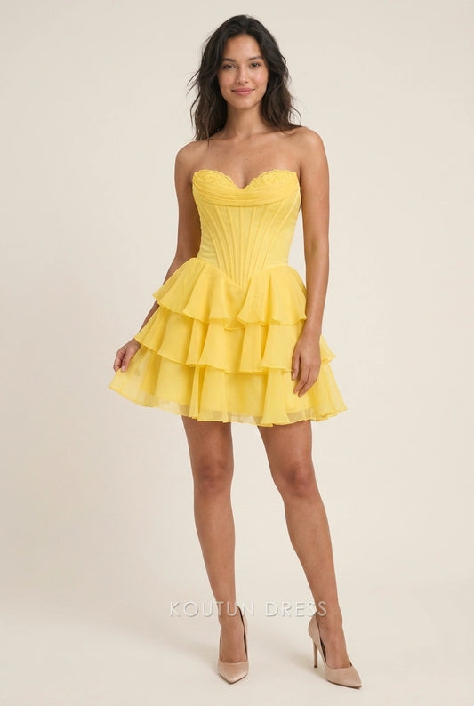 Model wearing a yellow strapless ruffled tiered short homecoming dress.