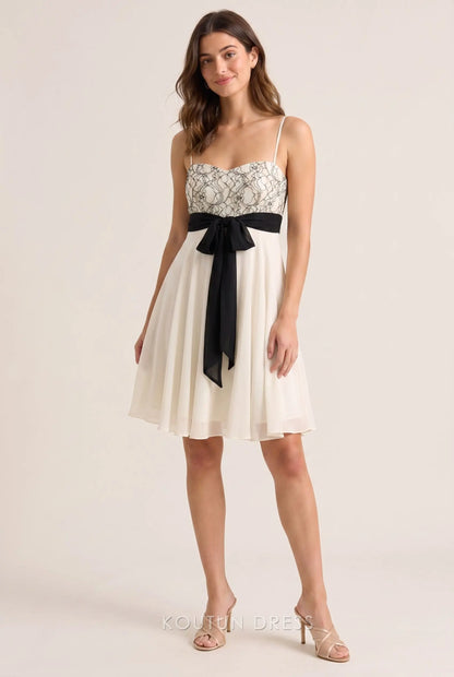 Ivory white A-line homecoming dress with lace bustier and black bow tie.