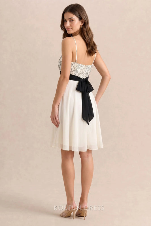 Back view of ivory white homecoming dress with black bow tie detail.