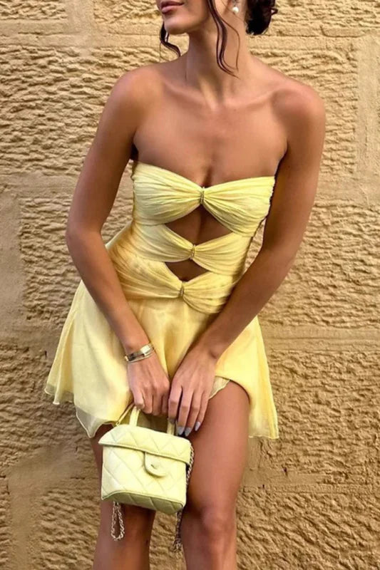 Model wearing a chic pleated strapless mini homecoming dress.