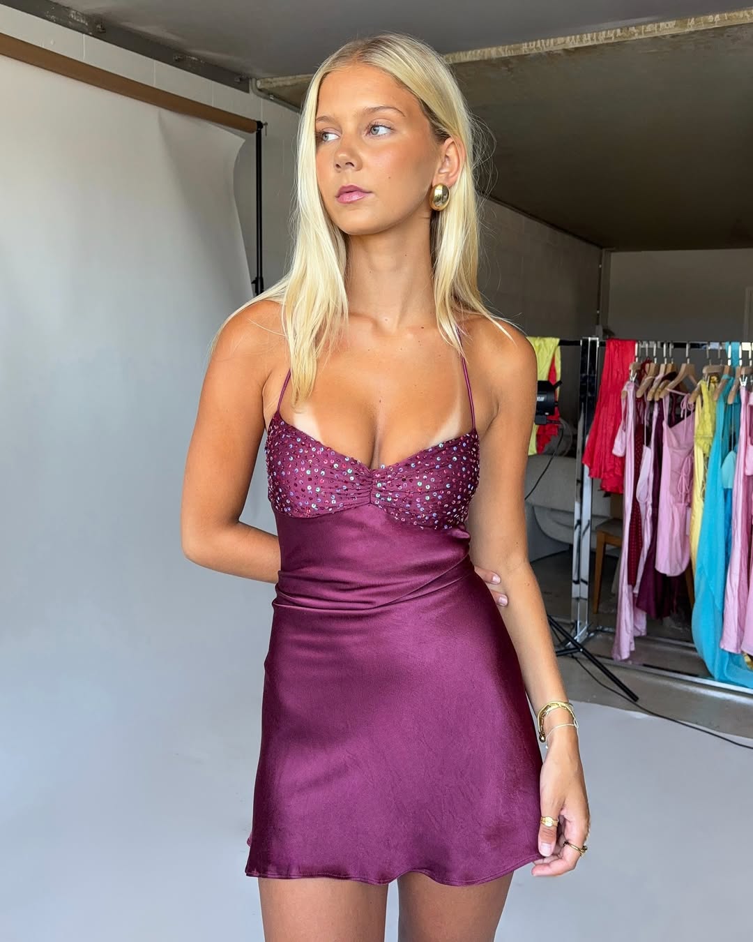 Model wearing a purple sheath homecoming dress with spaghetti straps and beading.