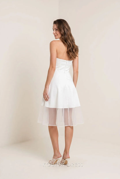 Back view of white strapless homecoming dress showing open back detail.