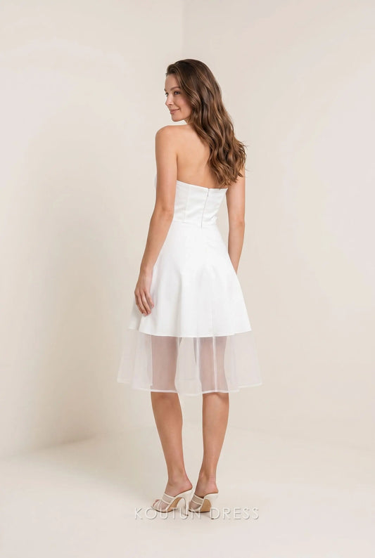 Back view of white strapless homecoming dress showing open back detail.