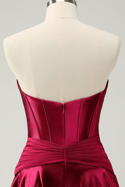 Model posing in a burgundy A-line strapless dress.