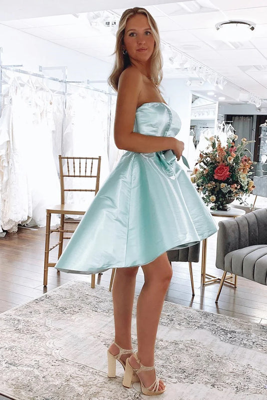 Side view of a model wearing the mint strapless high-low dress, showcasing the bow-knot.