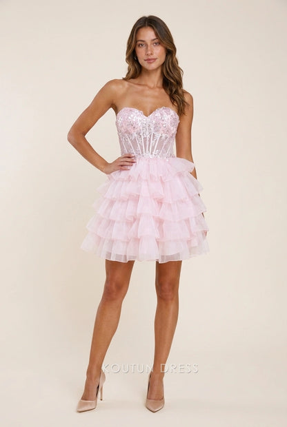 Model wearing a pink sequin strapless A-line short homecoming dress with tiered ruffles.