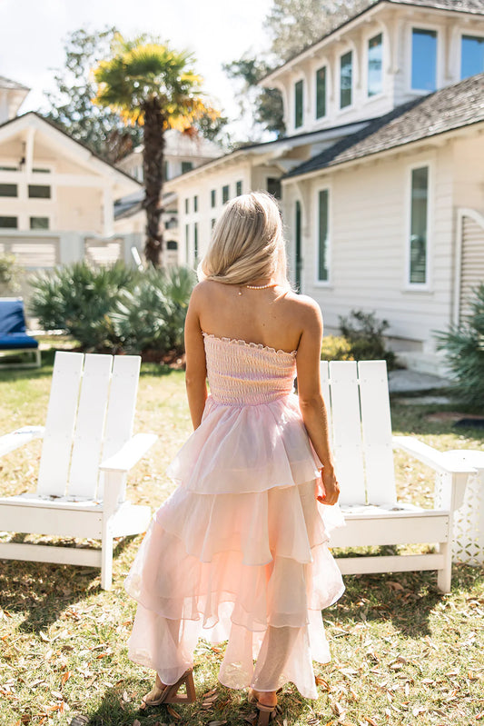 Back view of a soft pink strapless tiered ruffle chiffon maxi dress with an open back.