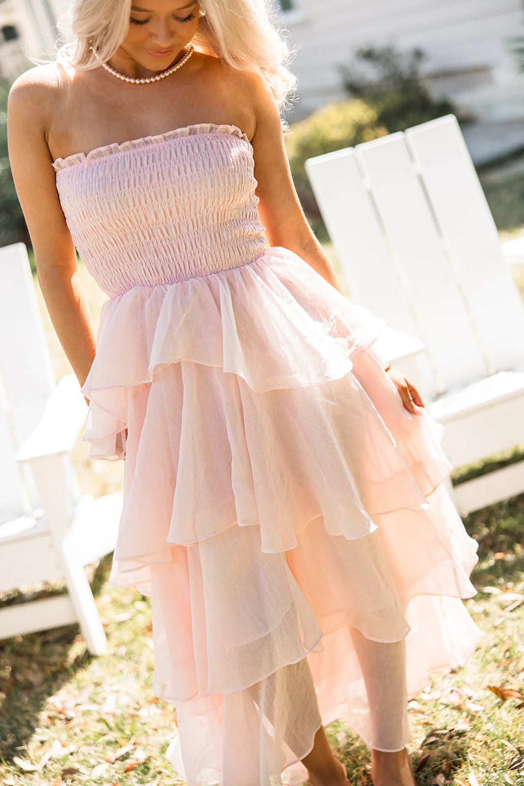 Model walking in a soft pink strapless tiered ruffle chiffon maxi dress, showcasing its movement.