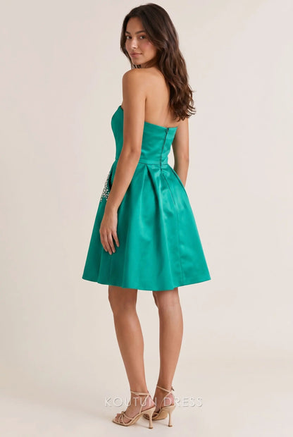 Back view of emerald green satin homecoming dress showing open back detail.