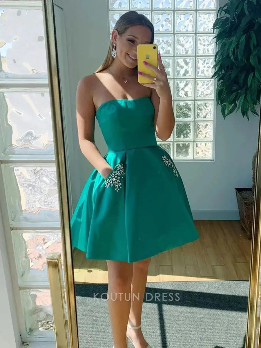 Close-up of rhinestone floral embellishment on pocket of emerald green dress.