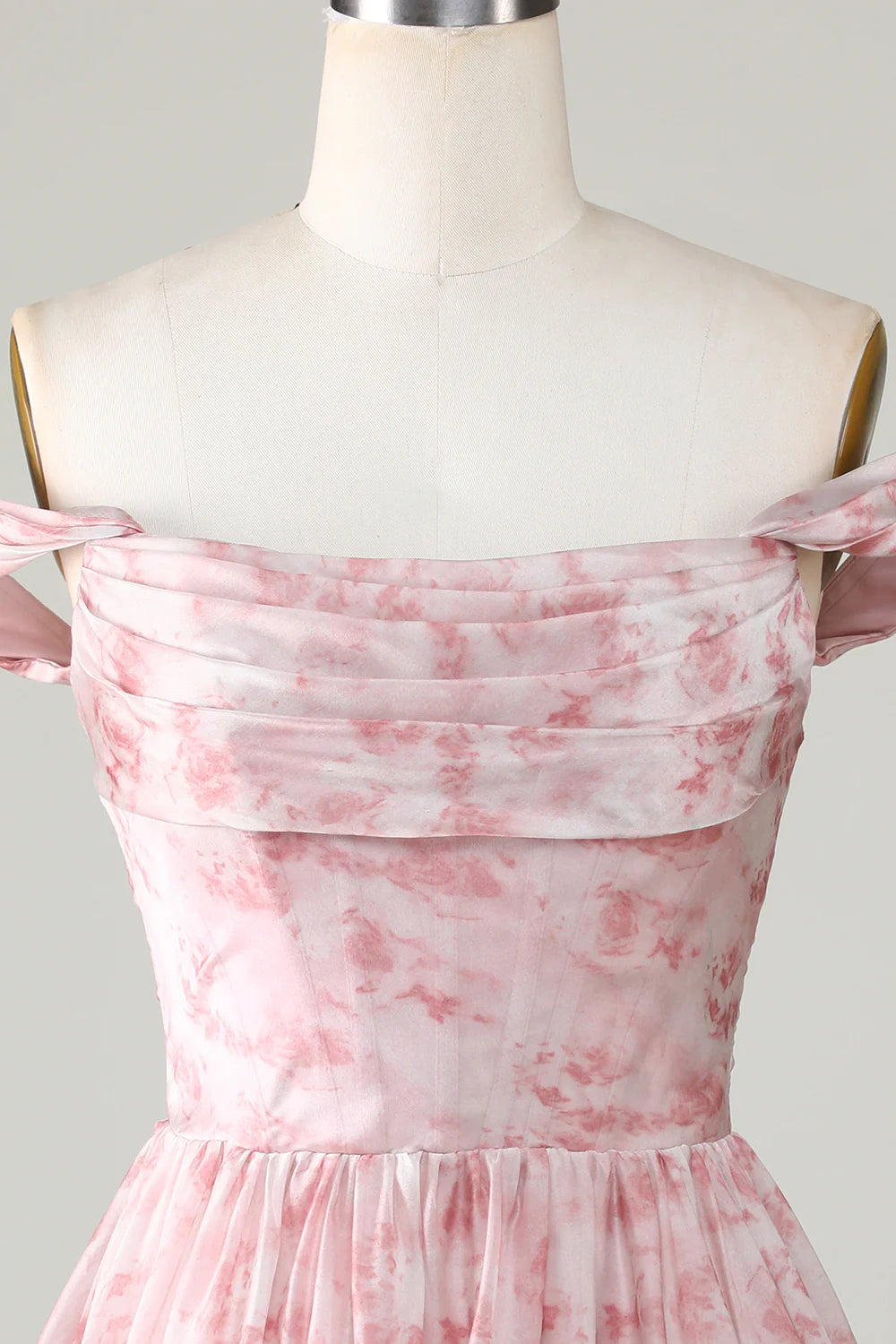 Close-up of the ruffled detail and floral print on a blush dress.