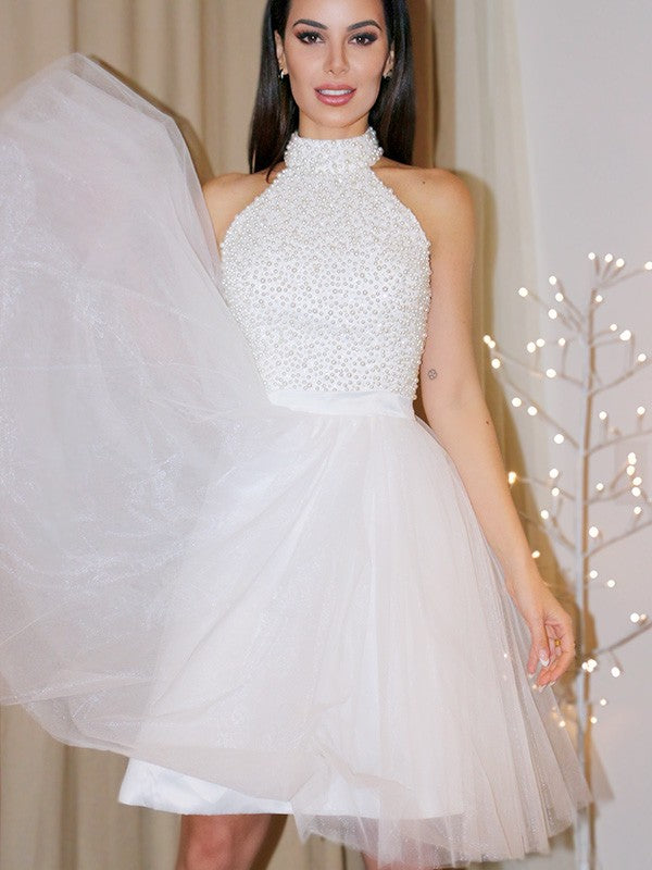 Koutun A-Line halter mini homecoming dress with beading and tulle.