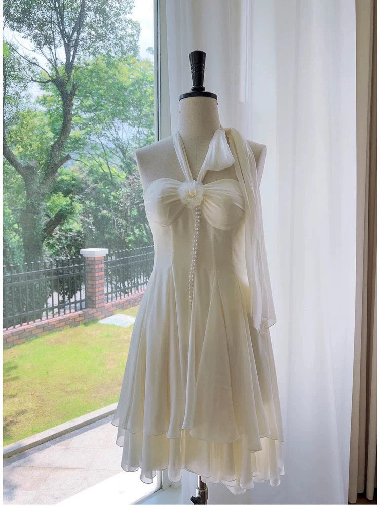 Front view of an elegant A-line halter neck chiffon short homecoming dress with bow and pearl detail.