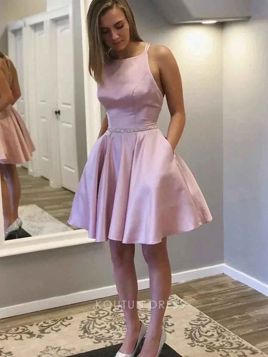 Close-up of the crisscross open back and rhinestone waistband on a blush pink dress.