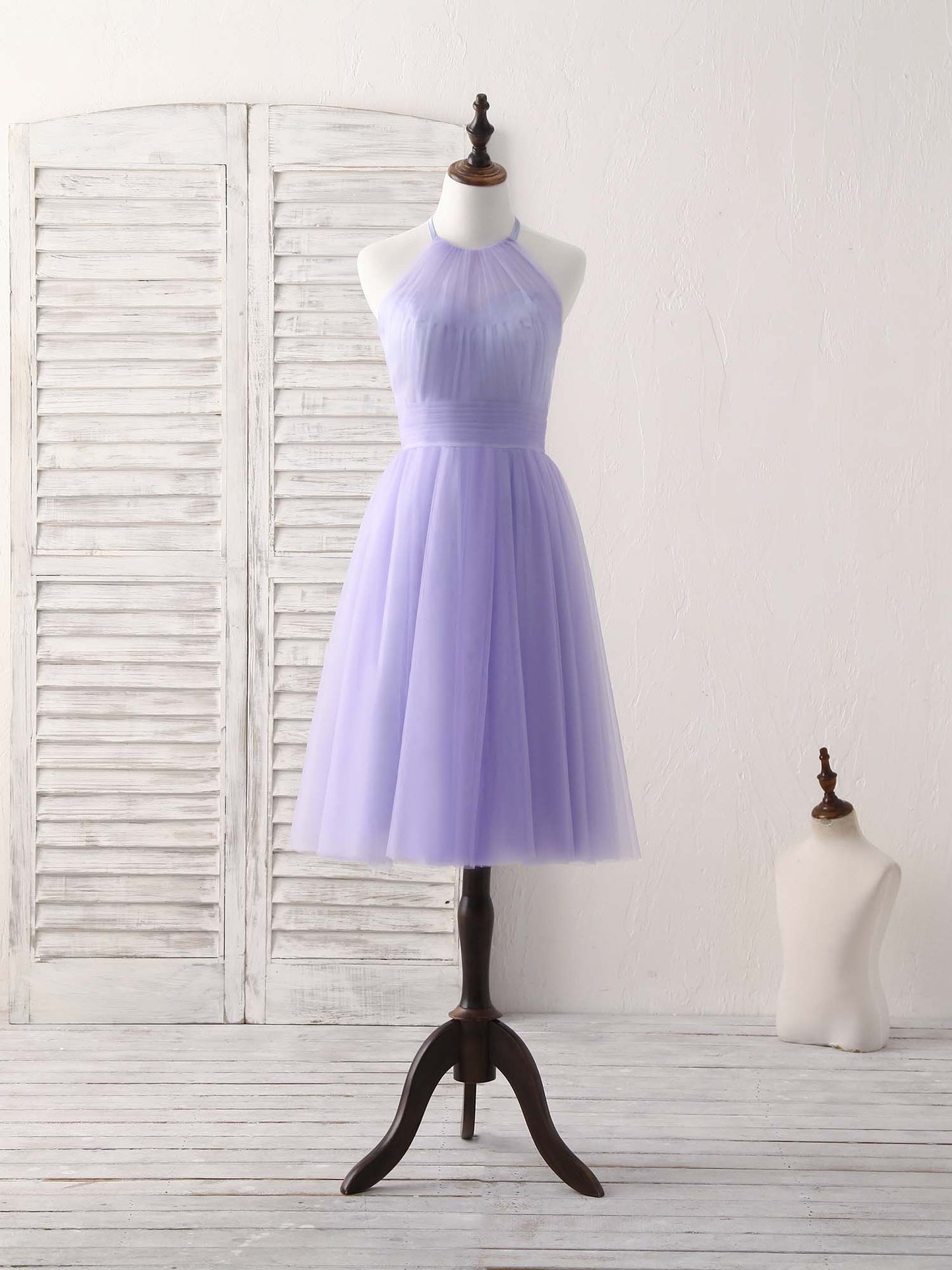Full view of a woman wearing a short purple A-line halterneck tulle dress.