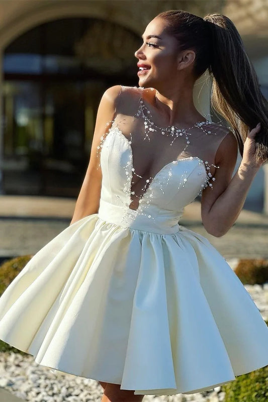 Elegant ivory A-line short homecoming dress with beaded illusion V-neck and sweetheart bodice.